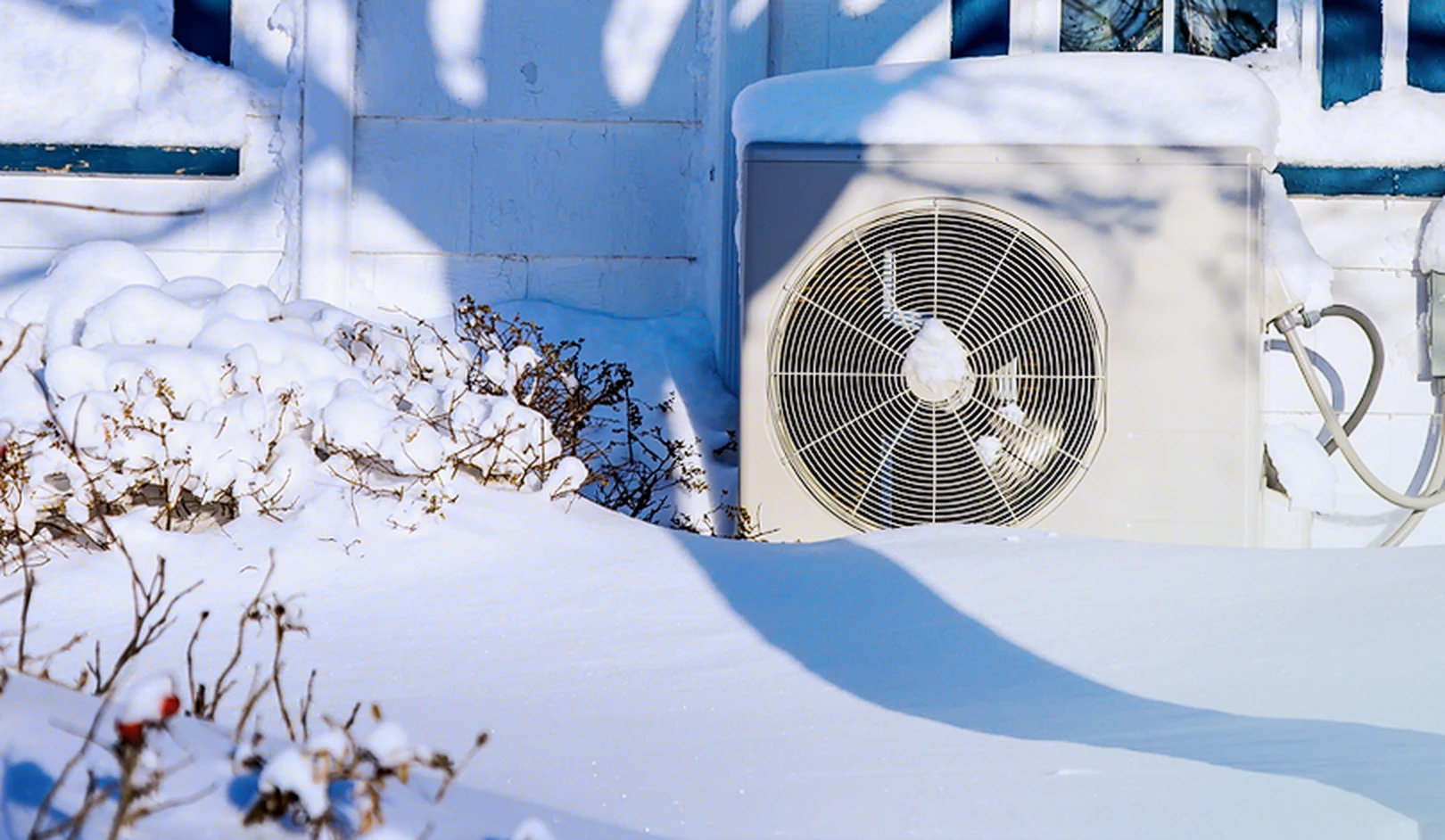 Air source heat pump working outside a UK home in winter