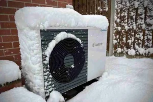 heat pump outdoor unit outside UK home in winter